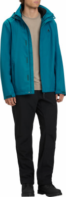 Ein Mann in einer blauen Jacke und schwarzen Hosen steht vor weißem Hintergrund. Ein Mann in einer blauen Jacke und schwarzen Hosen steht vor weißem Hintergrund.