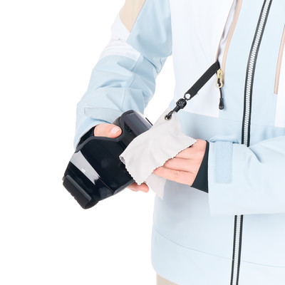 Eine Person reinigt ihre Snowboardbrille mit einem weißen Tuch. Eine Person reinigt ihre Snowboardbrille mit einem weißen Tuch.