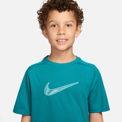 Junge in türkisfarbenem Nike-Shirt mit Logo auf der Brust. Junge in türkisfarbenem Nike-Shirt mit Logo auf der Brust.