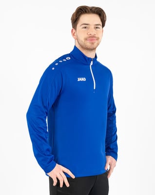 Junger Mann in blauer Jacke mit weißem Reißverschluss und JAKO-Logo. Junger Mann in blauer Jacke mit weißem Reißverschluss und JAKO-Logo.