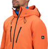 Ein Mann in einer orangefarbenen Kapuzenjacke mit schwarzen Reißverschlüssen.