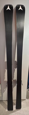 Zwei schwarze Skier mit weißem Logo oben, stehen nebeneinander.