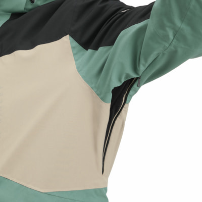 Detail einer Jacke mit Farbblöcken und Reißverschluss unter dem Arm.