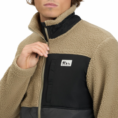 Mann in einem beigefarbenen Fleece-Reißverschluss mit schwarzen Einsätzen. Mann in einem beigefarbenen Fleece-Reißverschluss mit schwarzen Einsätzen.