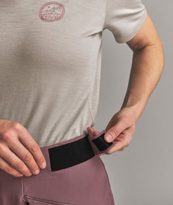 Detail der Hosenbund mit verstellbarem Klettverschluss, auf dem grauen Shirt ist ein Logo. Detail der Hosenbund mit verstellbarem Klettverschluss, auf dem grauen Shirt ist ein Logo.