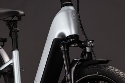Silberner E-Bike-Rahmen mit Vorderfederung und Licht. Silberner E-Bike-Rahmen mit Vorderfederung und Licht.