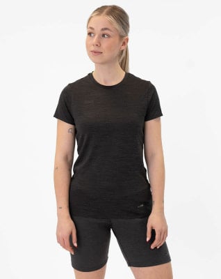 Eine Frau in einem schwarzen T-Shirt und Shorts steht vor einem weißen Hintergrund. Eine Frau in einem schwarzen T-Shirt und Shorts steht vor einem weißen Hintergrund.