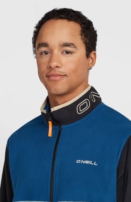 Ein Mann in einer blauen Fleecejacke mit O'Neill-Logo am Kragen. Ein Mann in einer blauen Fleecejacke mit O'Neill-Logo am Kragen.