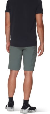Ein Mann in einem schwarzen T-Shirt und grünen Shorts mit Seitentaschen.