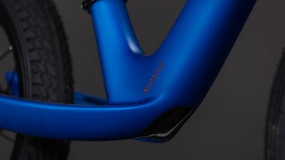 Blauer Fahrradrahmen mit orangefarbenem NUMOVE-Schriftzug und schwarzem Teil. Blauer Fahrradrahmen mit orangefarbenem NUMOVE-Schriftzug und schwarzem Teil.