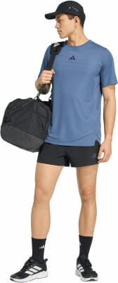Ein Mann in einem blauen T-Shirt und schwarzen Shorts trägt eine Tasche über der Schulter. Ein Mann in einem blauen T-Shirt und schwarzen Shorts trägt eine Tasche über der Schulter.