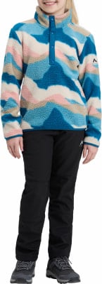 Mädchen in buntem Fleece-Pullover und schwarzer Hose mit Turnschuhen. Mädchen in buntem Fleece-Pullover und schwarzer Hose mit Turnschuhen.
