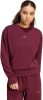 Ein Mädchen in dunkelweinroter Sportkleidung mit Adidas-Logo.