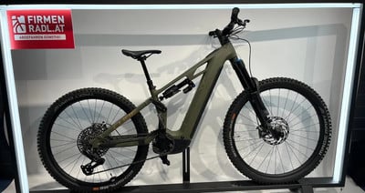 Ein grünes Cube E-Bike steht neben einer roten Werbung im Ausstellungsstand. Ein grünes Cube E-Bike steht neben einer roten Werbung im Ausstellungsstand.
