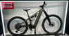 Ein grünes Cube E-Bike steht neben einer roten Werbung im Ausstellungsstand.