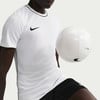 Ein Mann im weißen Nike-Trikot mit schwarzer Paspel hält einen weißen Fußball.