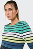 Eine Frau in einem gestreiften Langarmshirt mit buntem Streifenmuster.