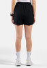 Eine Frau in schwarzen Shorts und weißen Socken steht mit dem Rücken zur Kamera.