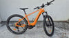 Ein orangefarbenes KTM E-Bike mit Federgabel und breiten Reifen steht an einer Wand.
