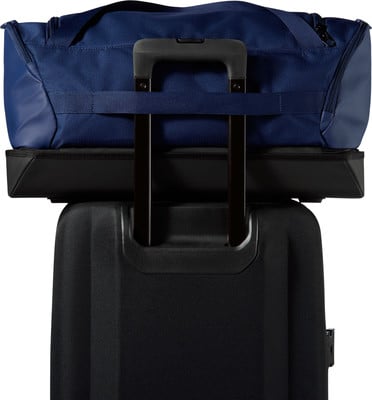 Eine blaue Reisetasche mit schwarzem Teleskopgriff oben.