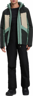 Ein Mann in schwarzer Hose und einer grün-beiger Jacke mit Kapuze.