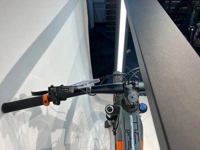 Detail des Mountainbike-Lenkers mit Bosch-Steuerung und orangefarbenem Griff. Detail des Mountainbike-Lenkers mit Bosch-Steuerung und orangefarbenem Griff.