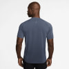Mann in einem dunkelblauen Kurzarm-T-Shirt mit reflektierenden Details am Rücken.
