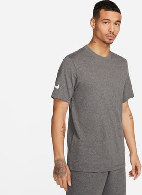 Ein Mann in einem dunkelgrauen T-Shirt mit Nike-Logo auf dem Ärmel. Ein Mann in einem dunkelgrauen T-Shirt mit Nike-Logo auf dem Ärmel.