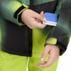 Hand steckt Karte in Ärmeltasche einer Jacke mit Grafikdruck.