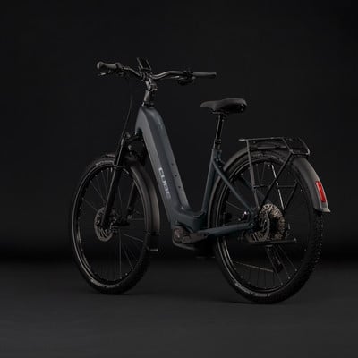 Graues Cube E-Bike mit Federung und Gepäckträger vor dunklem Hintergrund. Graues Cube E-Bike mit Federung und Gepäckträger vor dunklem Hintergrund.