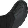 Detail eines schwarzen Winterstiefels mit gestepptem Textilobermaterial und Gummikappe.