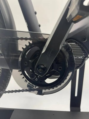 Detail des Kettenblatts eines E-Bikes mit Kette und Kunststoffschutz.