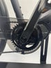Detail des Kettenblatts eines E-Bikes mit Kette und Kunststoffschutz.
