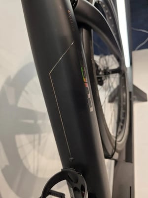 Detail des Rahmens eines schwarzen Fahrrads mit CUBE-Logo und Reflektor. Detail des Rahmens eines schwarzen Fahrrads mit CUBE-Logo und Reflektor.