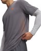 Mann in grauem T-Shirt mit orangefarbenem Logo und Punktmuster.