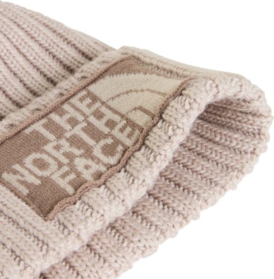 Detail einer beige Strickmütze mit dem The North Face Logo. Detail einer beige Strickmütze mit dem The North Face Logo.