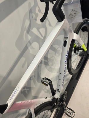 Ein weißes Rennrad mit blauer Cannondale-Aufschrift und rotem Muster. Ein weißes Rennrad mit blauer Cannondale-Aufschrift und rotem Muster.