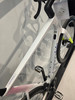 Ein weißes Rennrad mit blauer Cannondale-Aufschrift und rotem Muster.