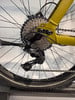 Schaltwerk an einem gelben Fahrrad mit Kassette und Kette.