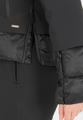 Detail einer schwarzen Daunenjacke mit gestepptem Saum und Reißverschluss. Detail einer schwarzen Daunenjacke mit gestepptem Saum und Reißverschluss.