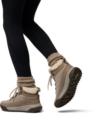 Die Frau trägt schwarze Leggings und braune Winterstiefel mit Fellbesatz. Die Frau trägt schwarze Leggings und braune Winterstiefel mit Fellbesatz.