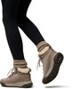 Die Frau trägt schwarze Leggings und braune Winterstiefel mit Fellbesatz.