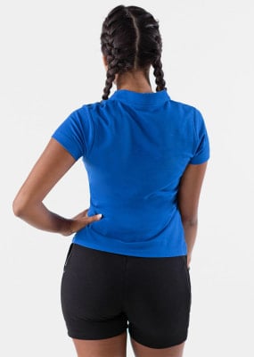 Rückansicht einer Frau in einem blauen Poloshirt und schwarzen Shorts mit Zöpfen. Rückansicht einer Frau in einem blauen Poloshirt und schwarzen Shorts mit Zöpfen.
