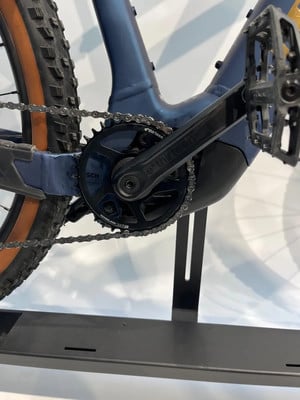 Detailaufnahme der Kurbel und Kette eines E-Bikes auf einem Ständer.