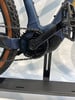 Detailaufnahme der Kurbel und Kette eines E-Bikes auf einem Ständer.