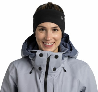 Eine Frau mit schwarzem Stirnband und grauer Jacke lächelt. Eine Frau mit schwarzem Stirnband und grauer Jacke lächelt.