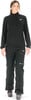 Frau in schwarzem Fleece-Pullover und Skihose mit Skischuhen.