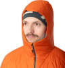 Ein Mann in einer orangefarbenen Kapuzenjacke und Strickmütze blickt zur Seite.