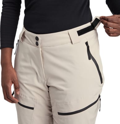 Detail einer Damen-Hose in Beige mit schwarzen Reißverschlüssen und Klettverschluss. Detail einer Damen-Hose in Beige mit schwarzen Reißverschlüssen und Klettverschluss.