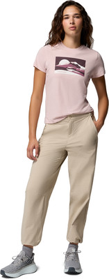 Model in rosa T-Shirt mit Bergprint und beiger Hose. Model in rosa T-Shirt mit Bergprint und beiger Hose.